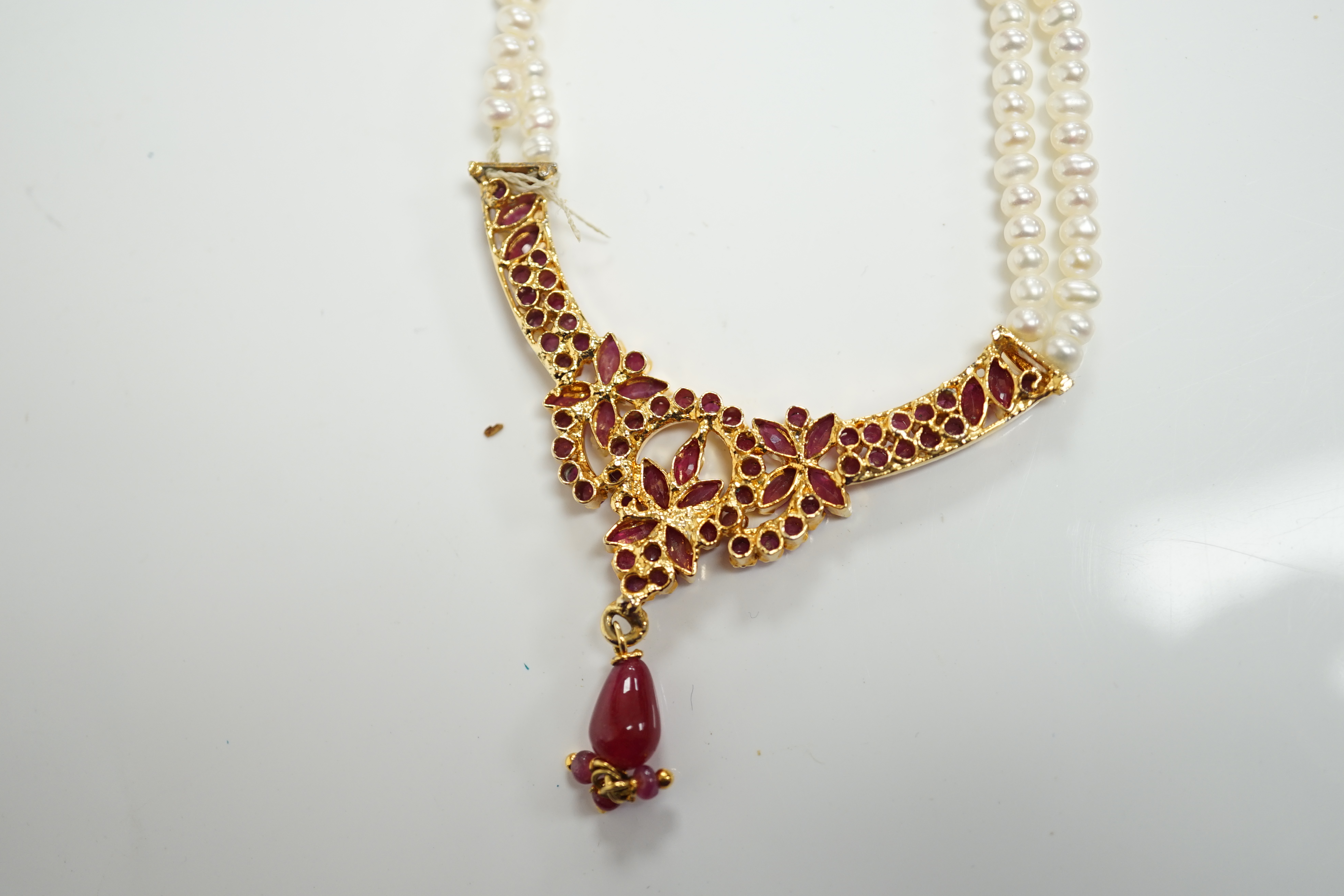 A recent Indian gilt metal and freshwater pearl and ruby cluster set twin strand necklace, 46cm and a pair of matching drop earrings. Condition - fair to good